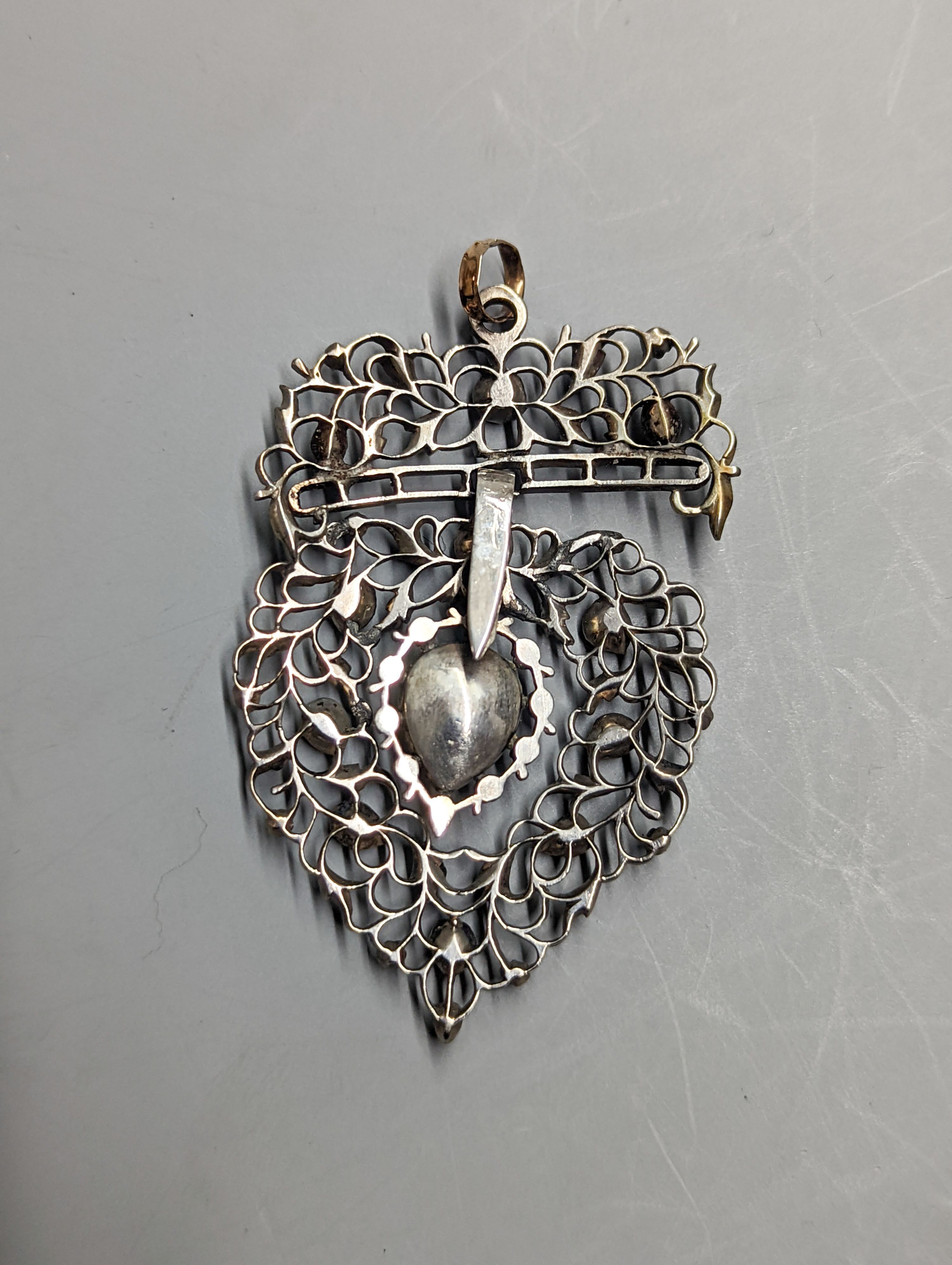 A late 19th century continental pierced white and yellow metal, rose cut diamond set heart shaped drop pendant, 62mm, gross weight 15.5 grams, in fitted box.